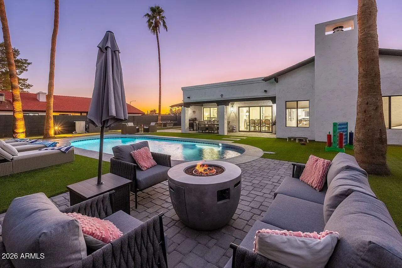 Firepit and pool at sunset with covered patio