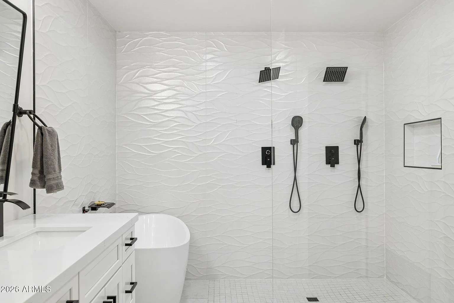 Walk-in shower with textured wave tile and freestanding tub